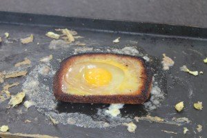 Eggs Being Cooked with Bread on a Open Camp Fire